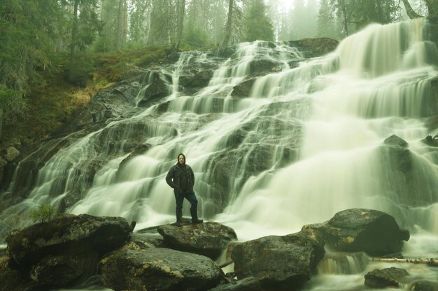 Photo man standing on rocks in forest