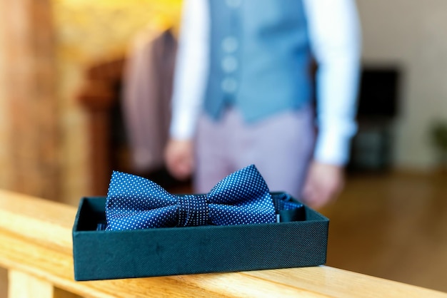 部屋に立って蝶ネクタイを着る準備をしている男性結婚式の前に朝の準備をしている新郎男性のファッションコンセプト