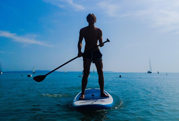 Man standing in sea against sky