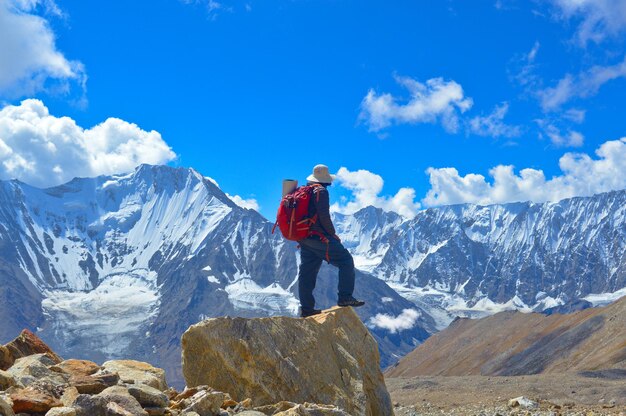 Man standing on snowcapped mountain against sky