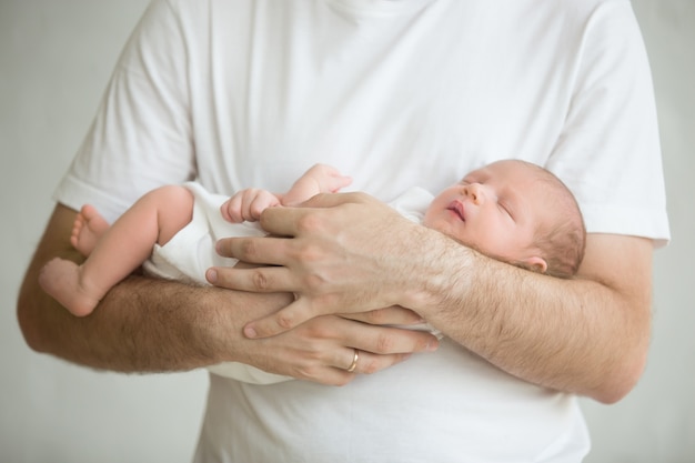 写真 男の腕の中で赤ちゃんと一緒に立って