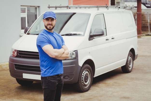 Man standing with arms crossed in front of his van