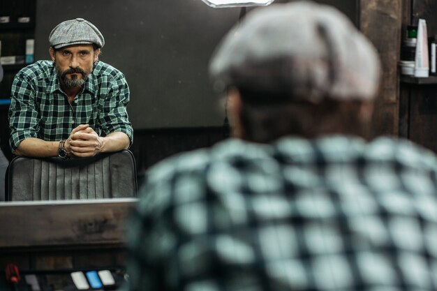 man standing with his hands on the barbershop chair