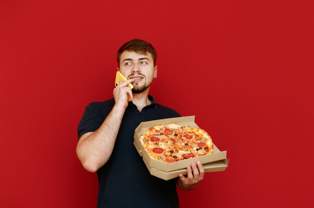 Man standing with pizza box in hand and making photo