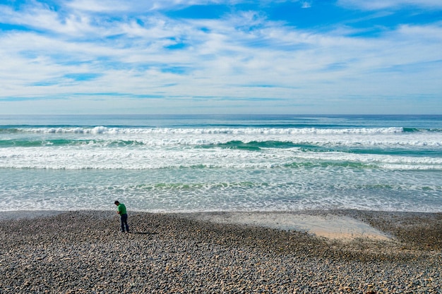 海の前のビーチに男が立っています。