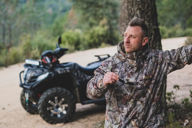 A man stands in front of a tree and looks at the camera.