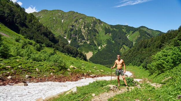 男は、ロシアのソチ山脈の氷河に立っています