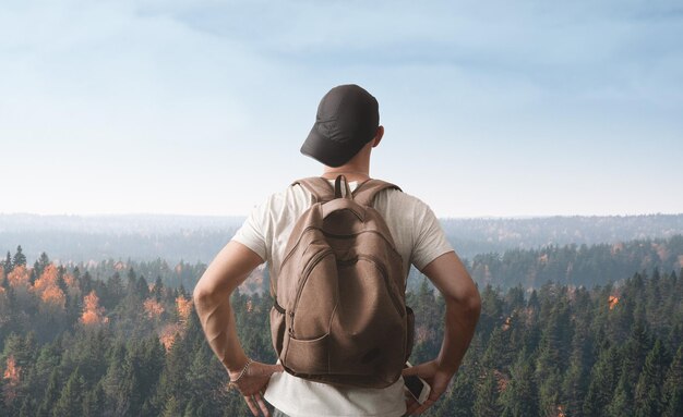 A man stands on a hill and looks at the forest far from civilization concept