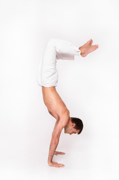 Man stands on his hands in yoga pose.