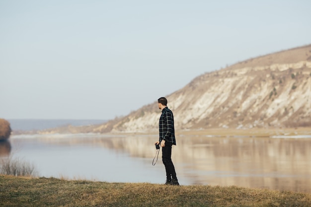 man stands near the lake in the mountains