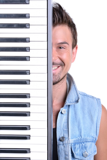 Man stands at the piano and smiles.