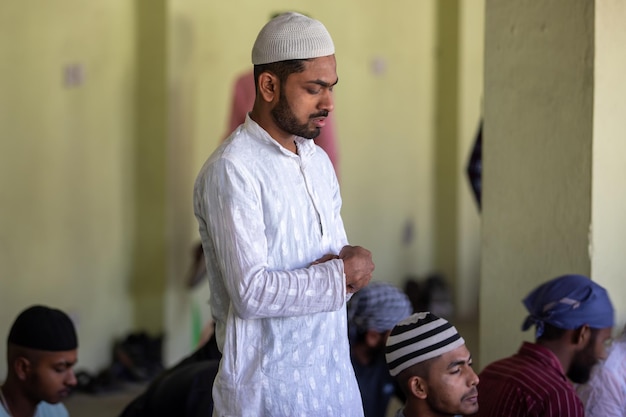 A man stands in a prayer room with his hands on his head.