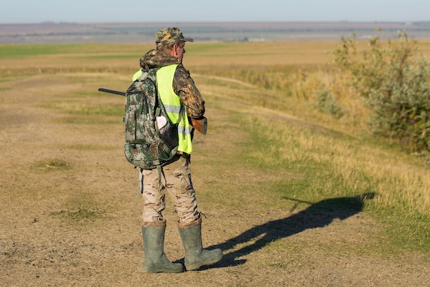 A man stands with weapons and hunting dogs tracking down the game