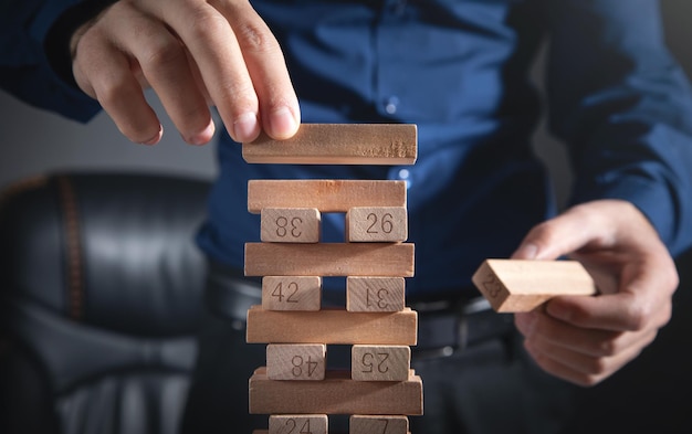 Man stapelen een houten blokken. Bedrijf. Plan. Strategie