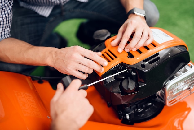 A man starts a lawnmower motor in the store.