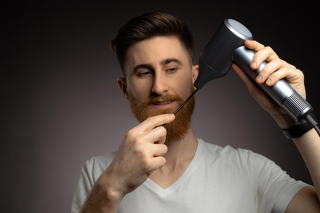 A man steals a mustache with a hairdryer in his hands