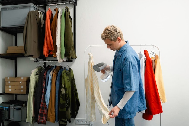 man steaming clothing in a wardrobe