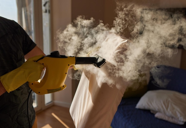 Photo man steaming pillow at home closeup view