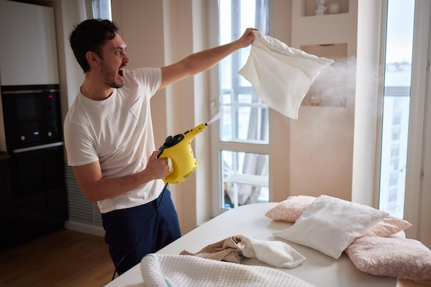 Man steaming pillow at home closeup view