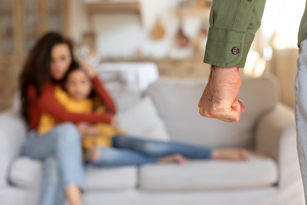 Man steekt de hand uit naar zittende vrouw en meisje