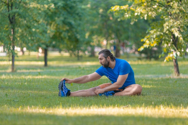 Man stretches outdoor in summer time