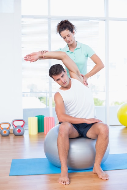 Man stretching his arm with trainer