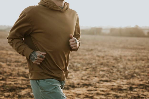 Man in stretchy hoodie in the countryside at sunset