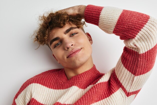Man in striped sweater posing on white background