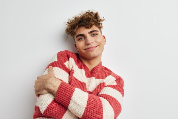 Man in striped sweater posing on white background