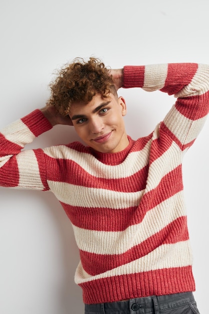 Man in striped sweater posing on white background