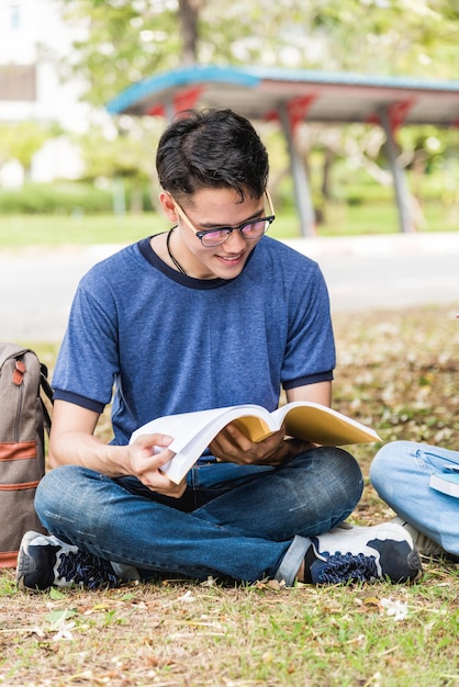 Man studenten buiten zijn tijdens het lezen van boeken, onderwijsconcept