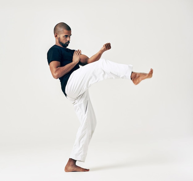 man studio and martial arts for training practice action and karate exercise on white background black male person mockup space and strong for combat fight and position of attack in kung fu