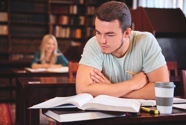 Photo man studying at desk in library