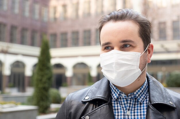 Man in stylish clothes on the street with a medical face mask on, outbreak of viral disease coronavirus covid-2019