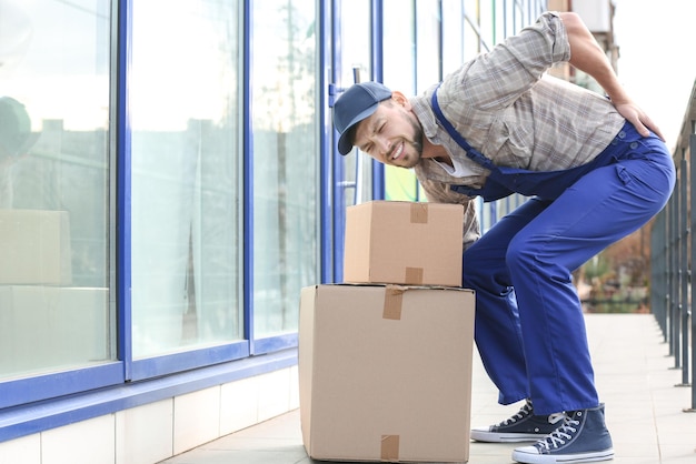 Photo man suffering from back ache while moving boxes