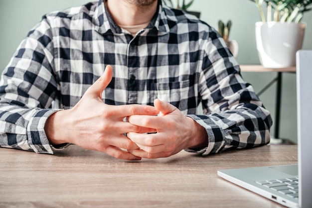 A man suffering from joint pain in his hand and wrist rheumatoid arthritis and occupational disease