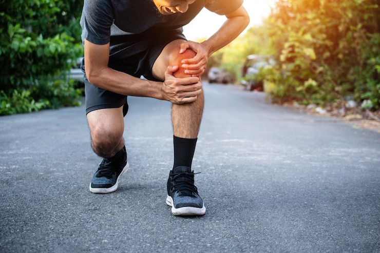 Photo man suffering from knee pain on road