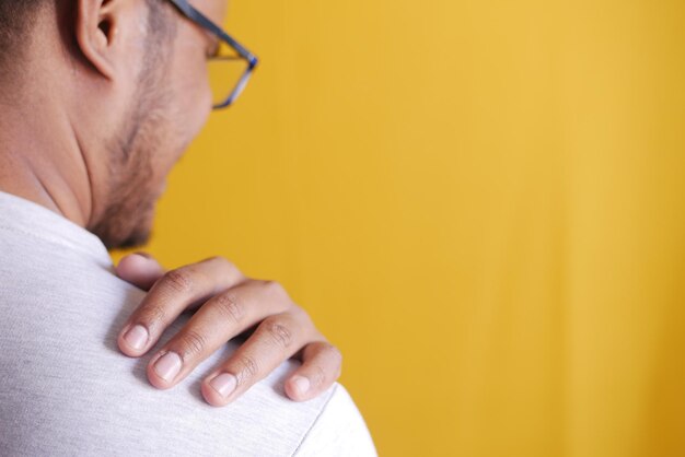 Photo man suffering from neck or shoulder pain at home