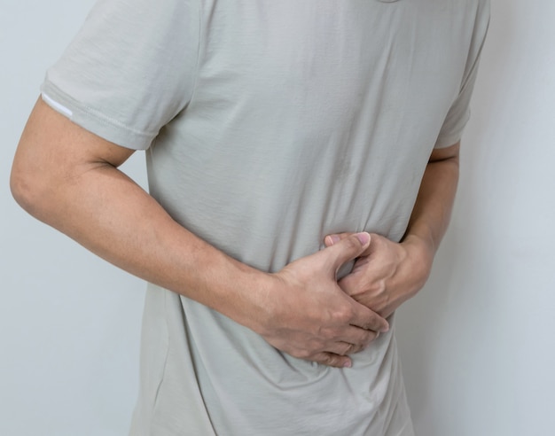 Man suffering from stomach ache with both palm around waistline to show pain and injury on belly area