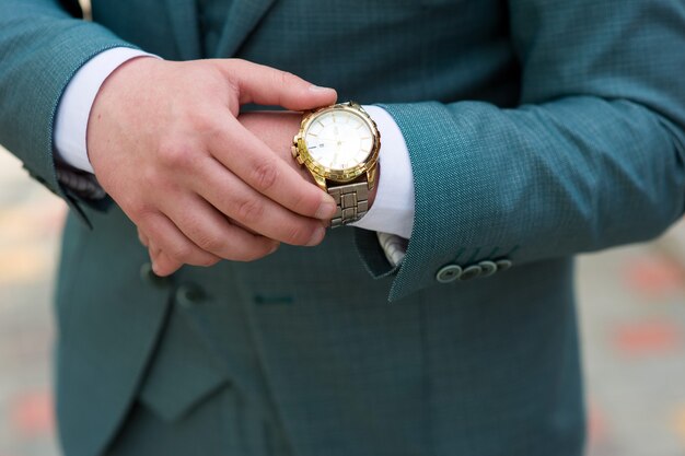 Man in a suit adjusts his watch, close-up