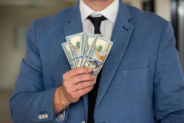 Man in suit counting us money dollar savings and finances concept