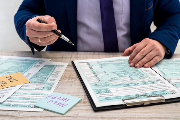 Man in a suit fills out the usa individual 1040 tax form. tax time. Accounting concept