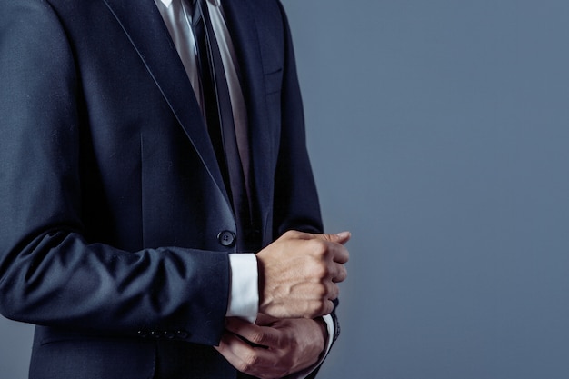 Man in suit on a grey, hands closeup