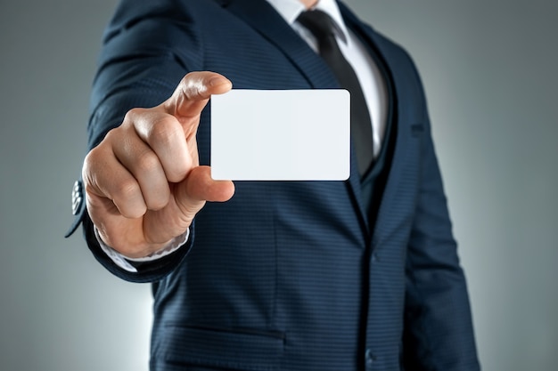 A man in a suit hands close-up shows a business card. mockup, layout.