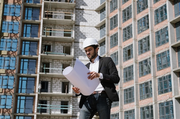 Uomo in tuta e casco con blueprint