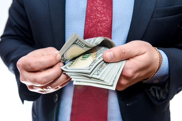 Man in suit holding dollar banknotes close up