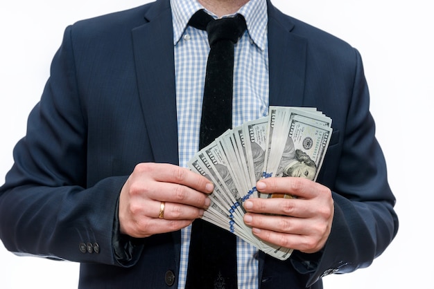 Man in suit holding pile of dollar banknotes