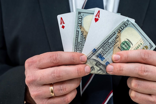 Man in suit holding play card with us dollar bills