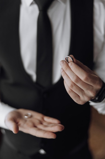 A man in a suit holding a ring in his hand
