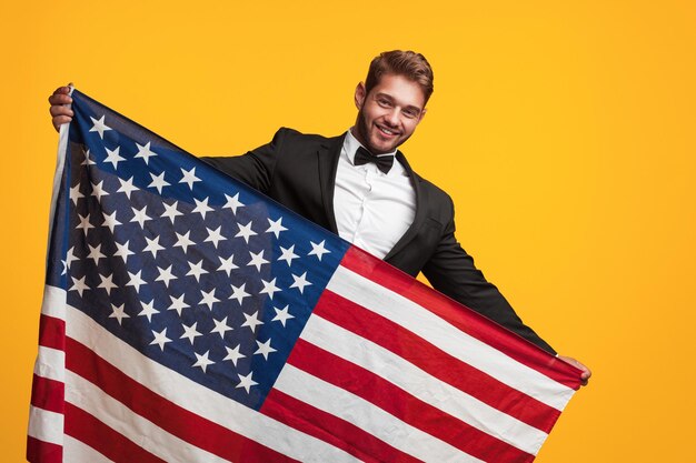 Photo man in suit holding usa flag